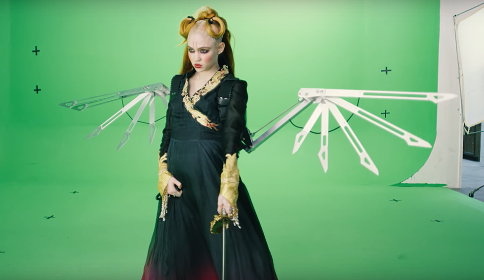 Grimes performs against a green screen for her latest single, You'll Miss Me When I'm Gone