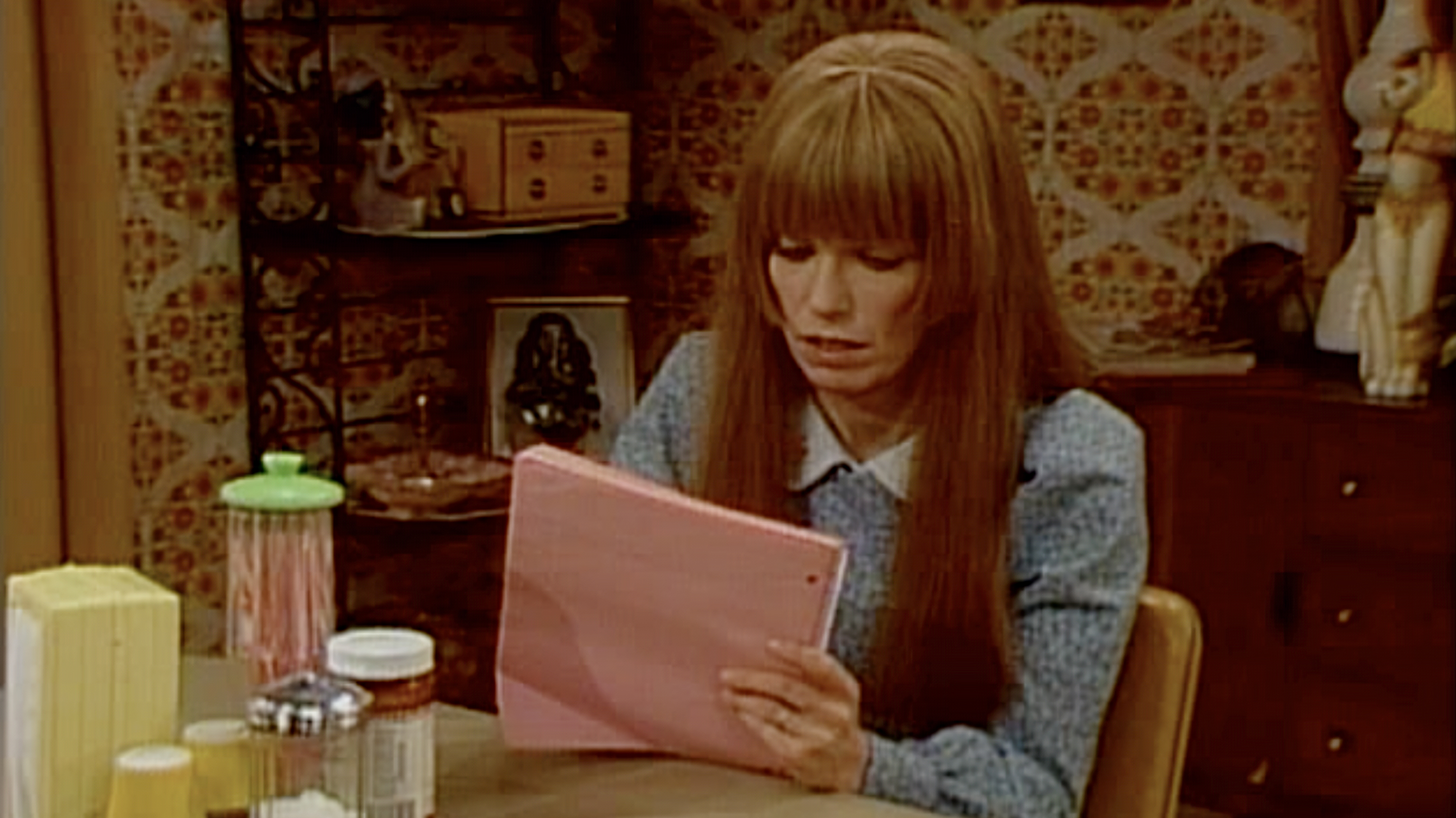 The title character of 'Mary Hartman, Mary Hartman' sits at her kitchen table writing in her journal