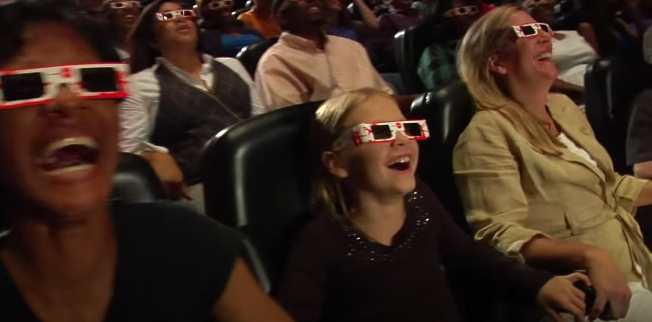 Audience members at the World of Coca-Cola wear 3-D glasses while watching a video.