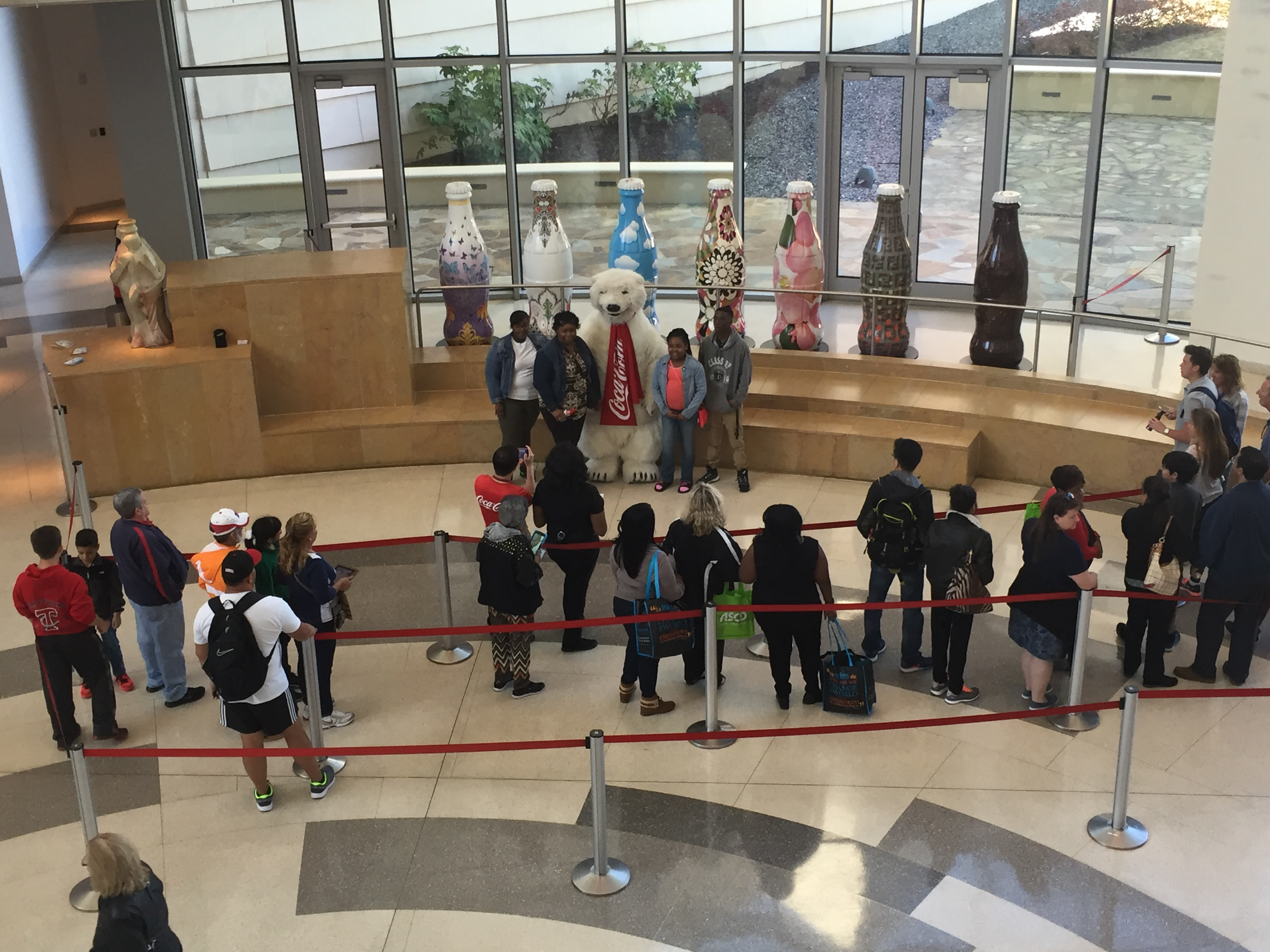 Visitors wait in line to take a photo with a polar bear mascot.