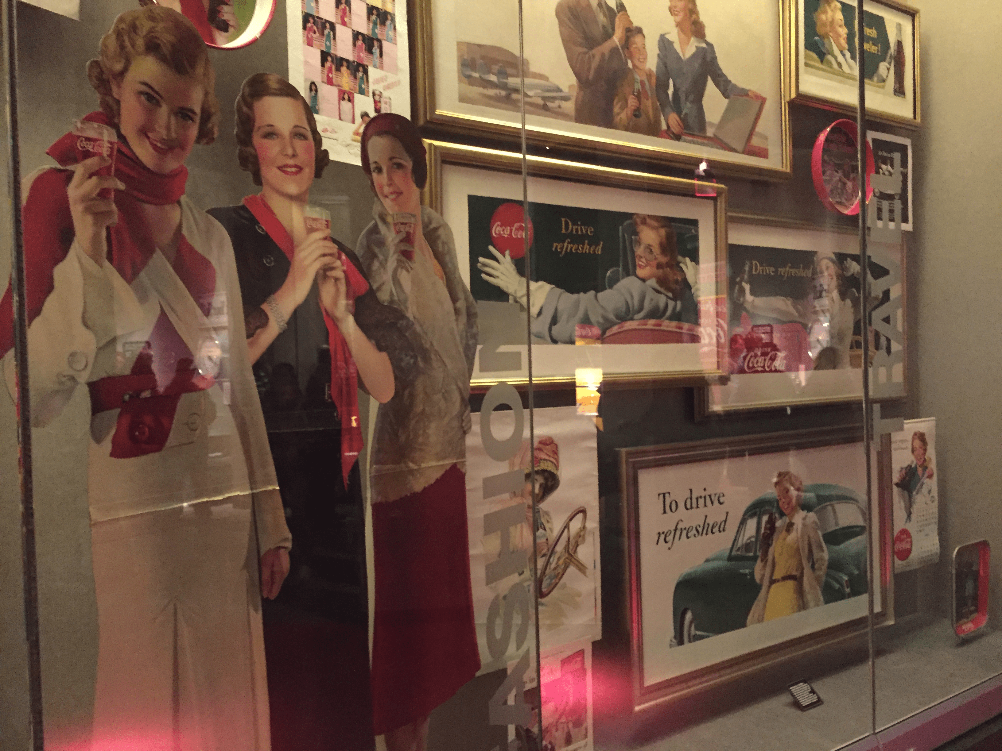 A variety of old Coca-Cola ads that say 