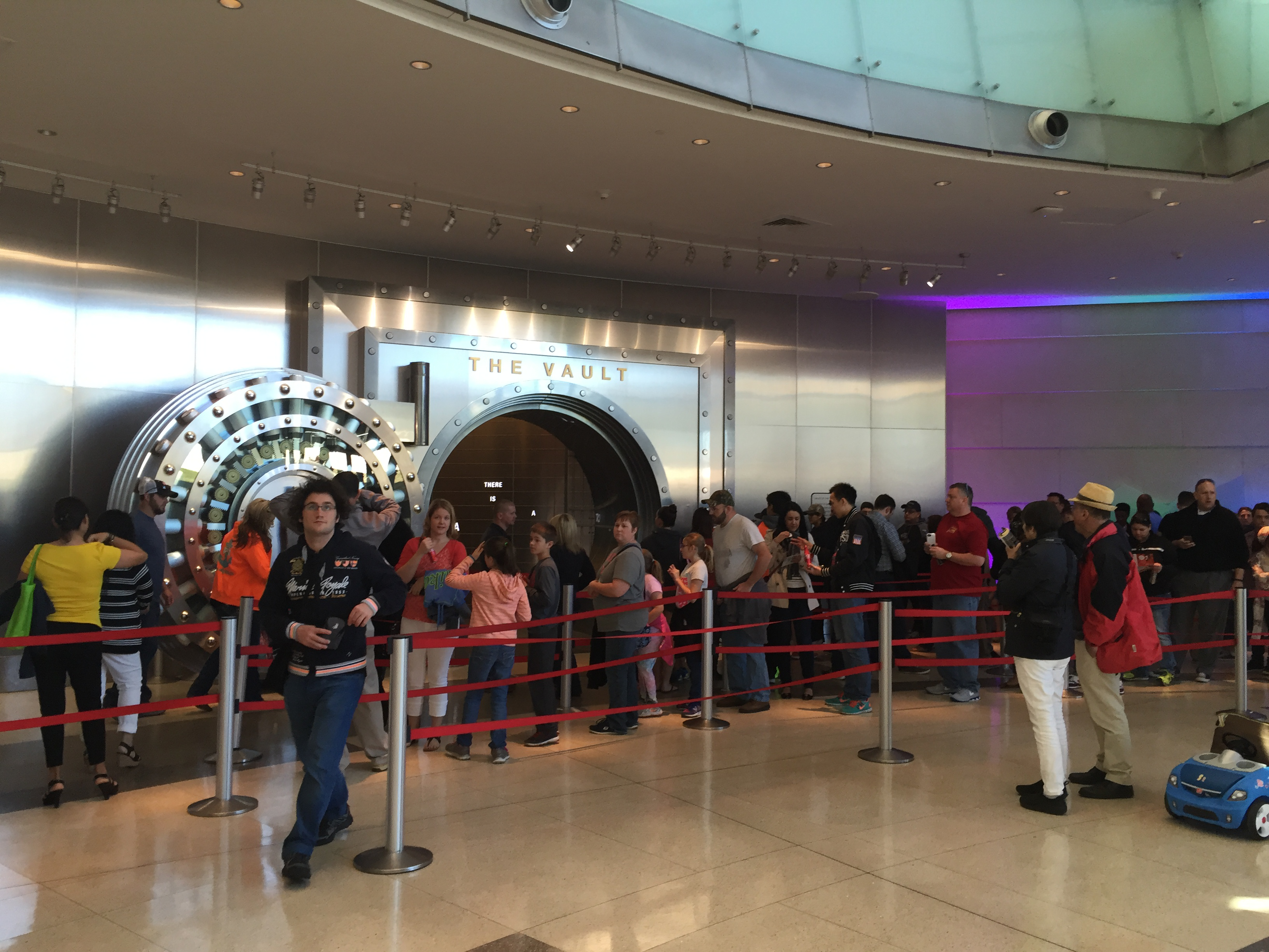 Line of visitors waiting to enter through a doorway marked 