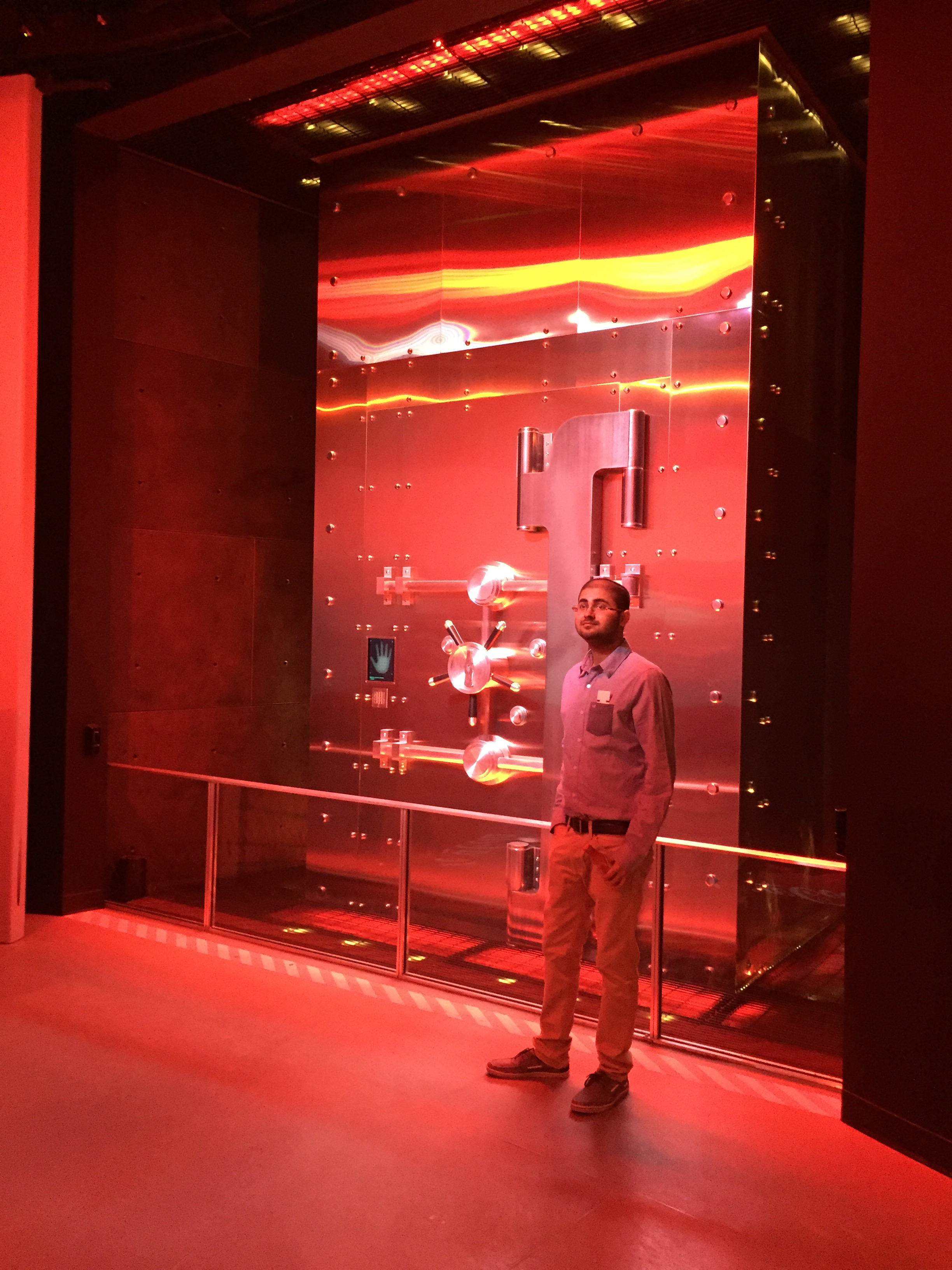 An employee stands in front of a metal vault door.
