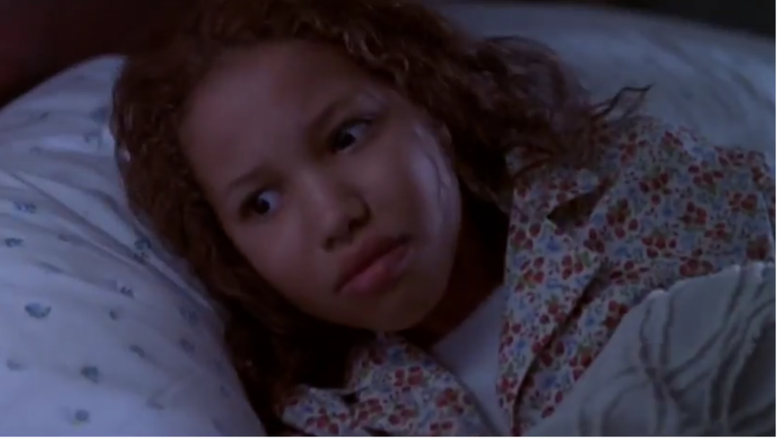 Eve (Jurnee Smollett) awakens, scared in bed