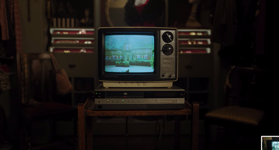 An old fashioned televisions set depicting an ivy covered brick building