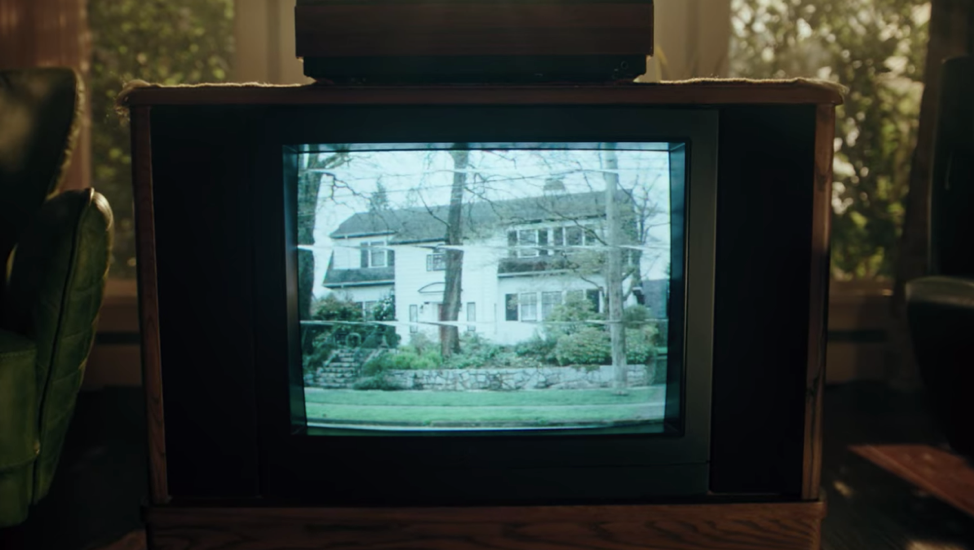 An old television set showing a suburban home