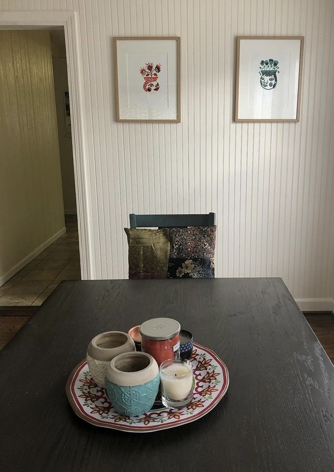 Alyx Vesey's dining room office, featuring two framed screenprints on the wall.