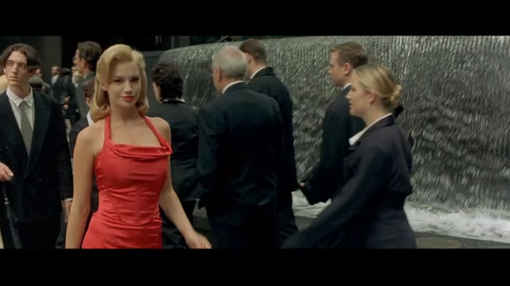 A woman in a red dress walks down a New York street