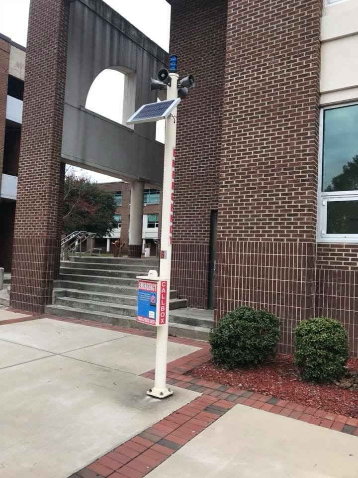 Multipurpose blue light phone and speaker system pole, on a college campus