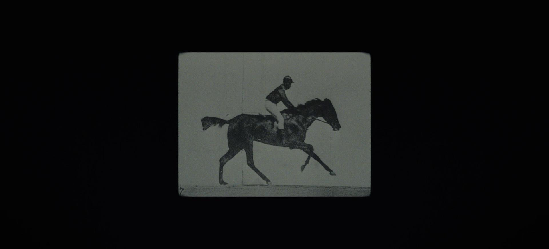 Black and white still of a man on a horse