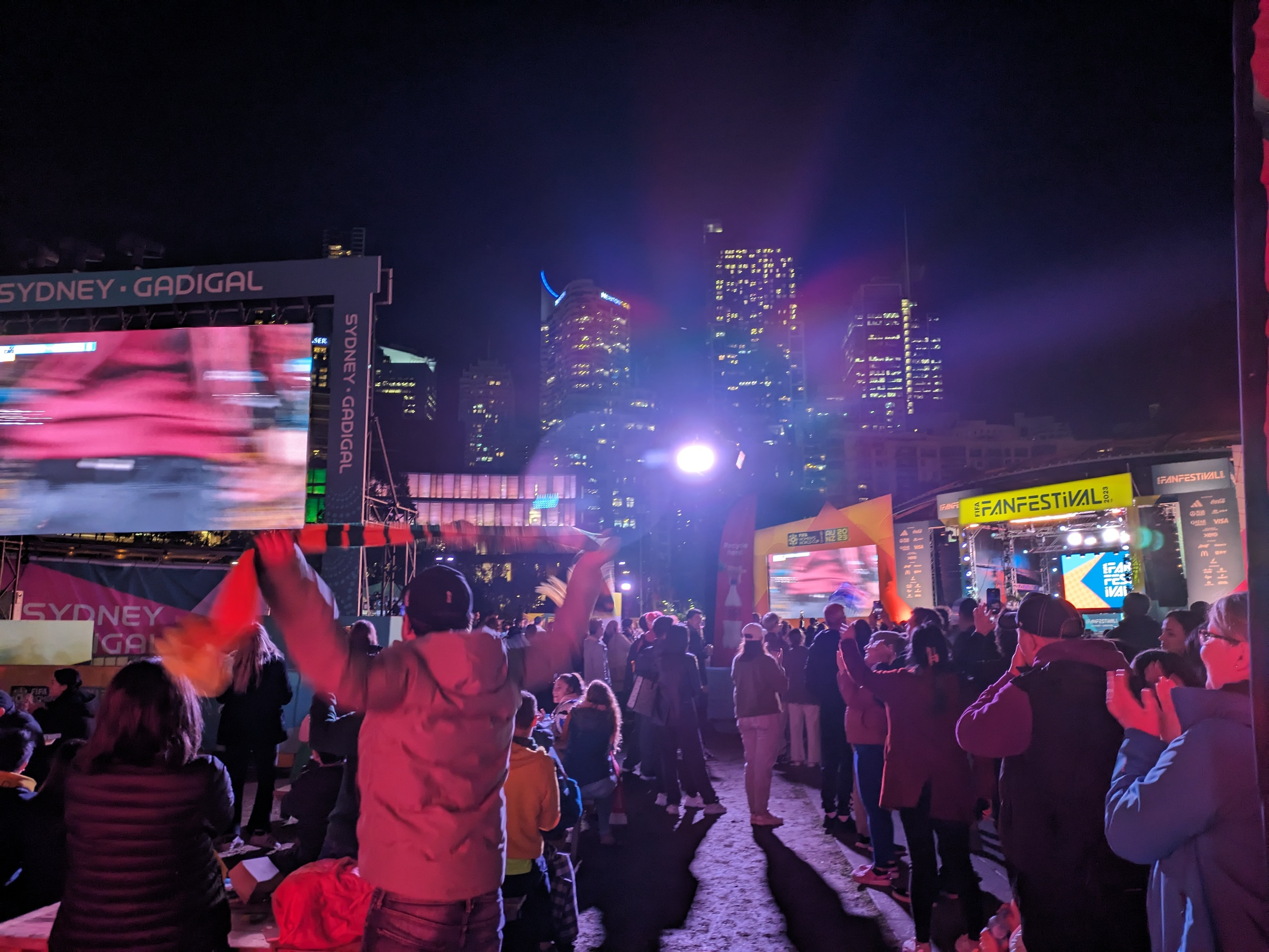 Soccer fans cheer in front of a screen