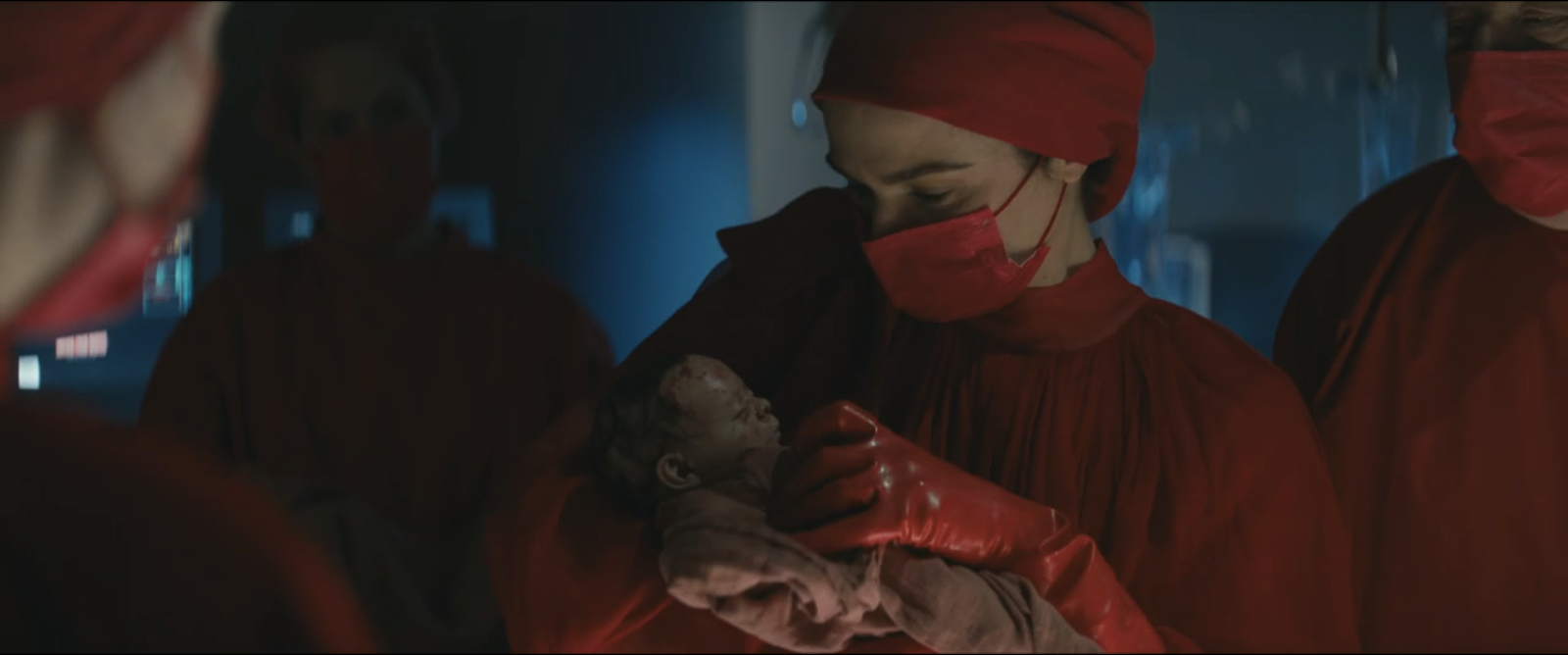 Image of doctor all in red holding newborn baby