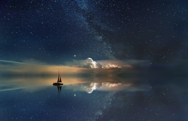 Black sailing boat with stars in the background