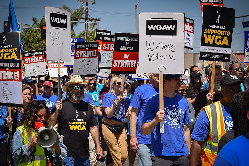 Striking members of the Writers Guild of America holding picket signs