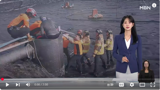 South Korean newscaster in front of image of industrial workers